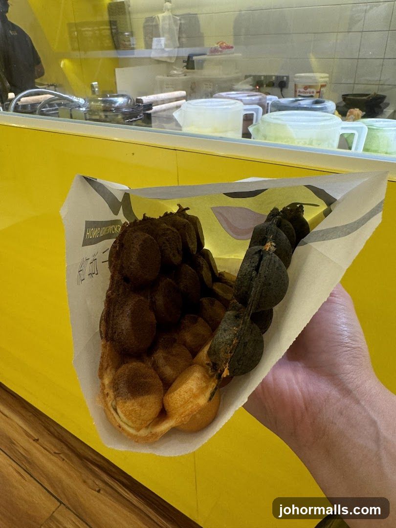Hand holding waffle snacks in paper wrapper