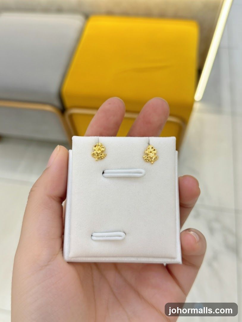 Hand holding gold earrings on display card