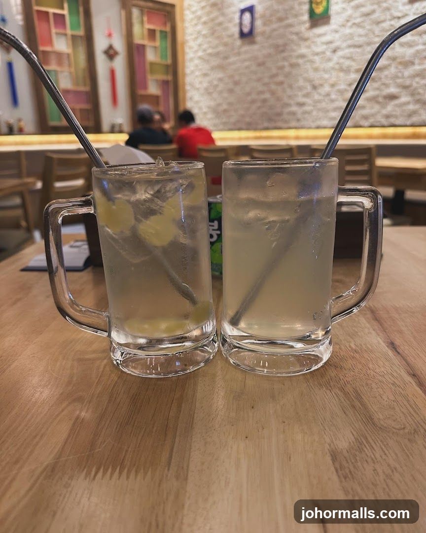 Two mugs of iced drink on wooden table