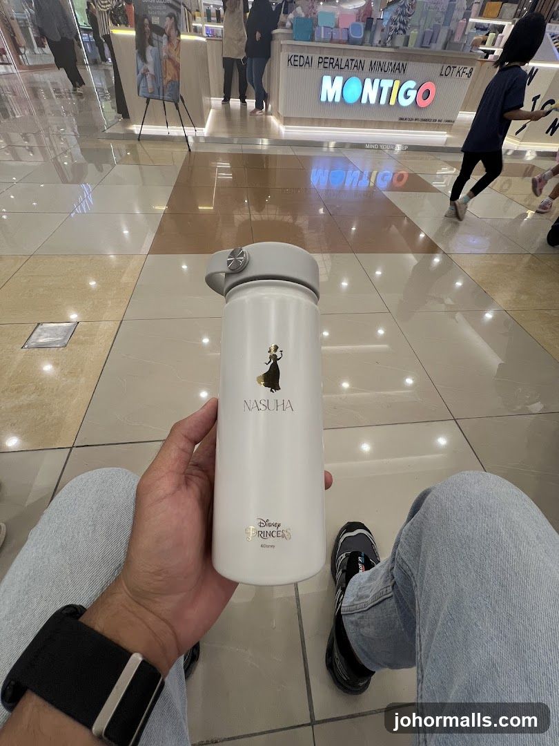 Person holding a water bottle in a mall