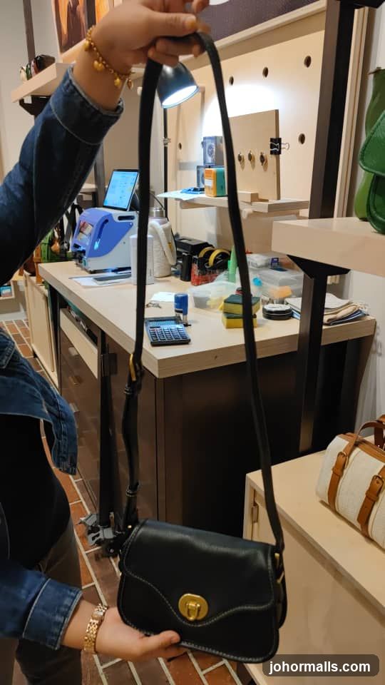 Person holding a black handbag