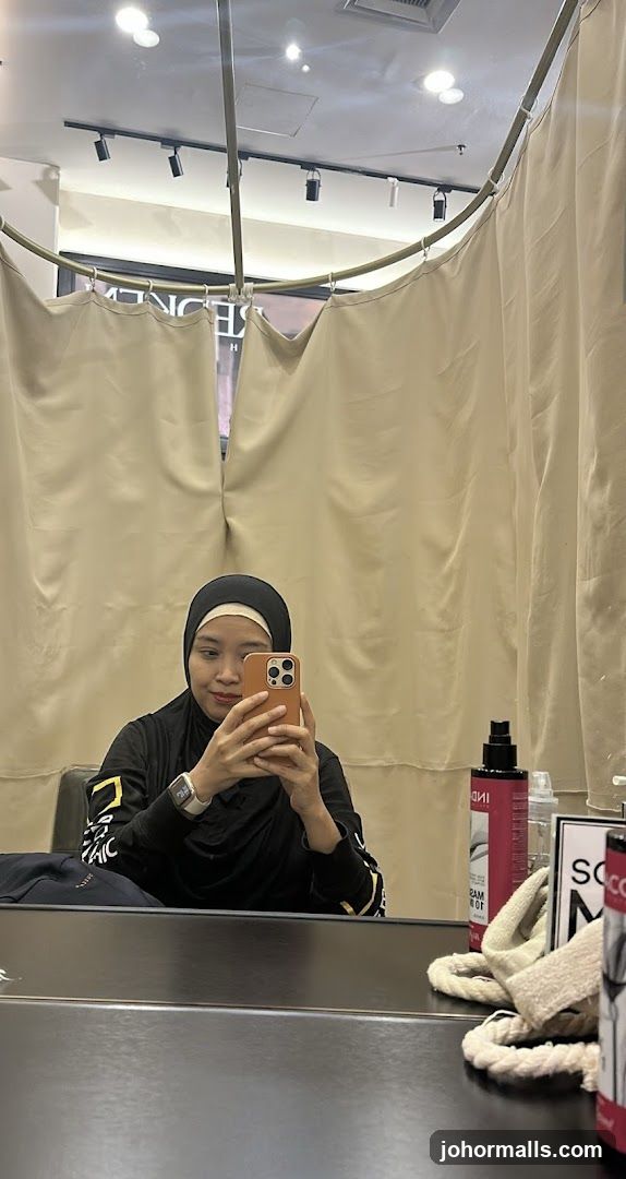 Woman taking a mirror selfie in a salon