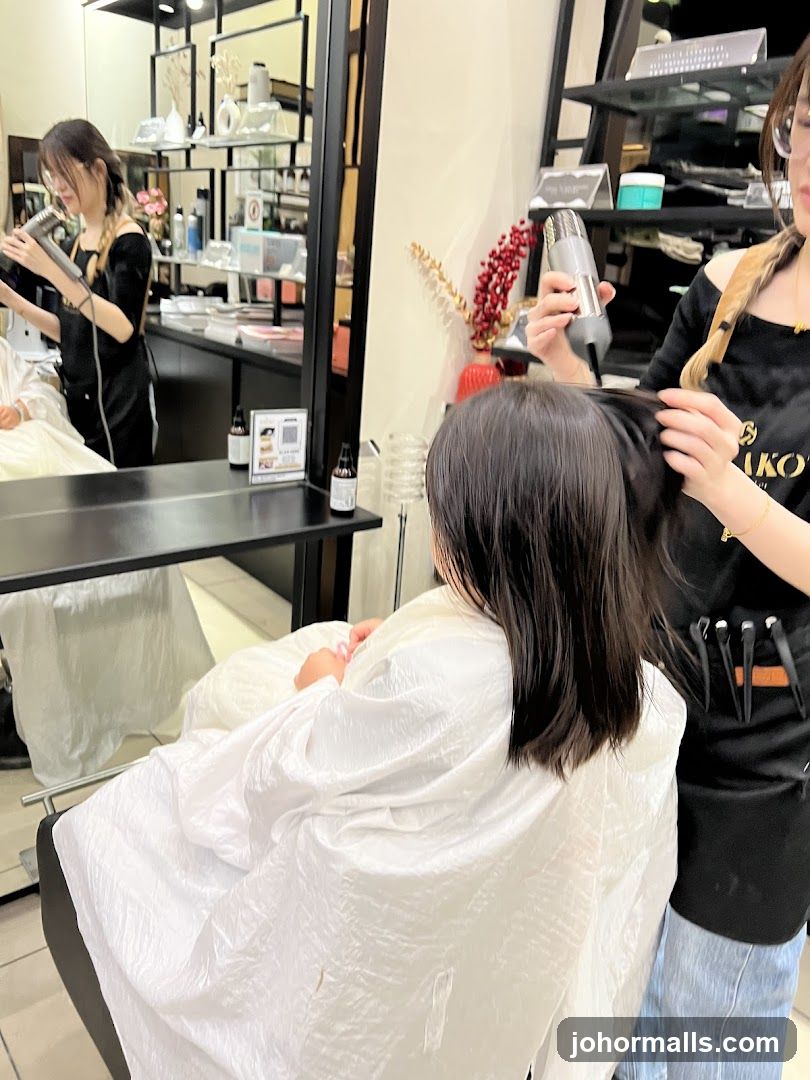 Hairdresser drying client's hair