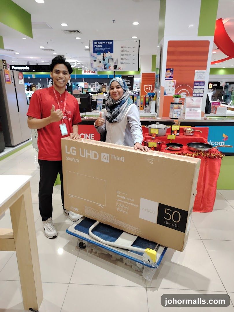 Two people with a large TV box
