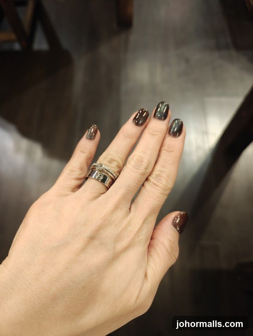 Woman's Hand with Dark Nail Polish and Rings