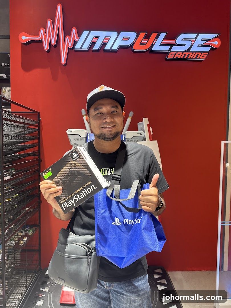 Man holding PlayStation controller and bag