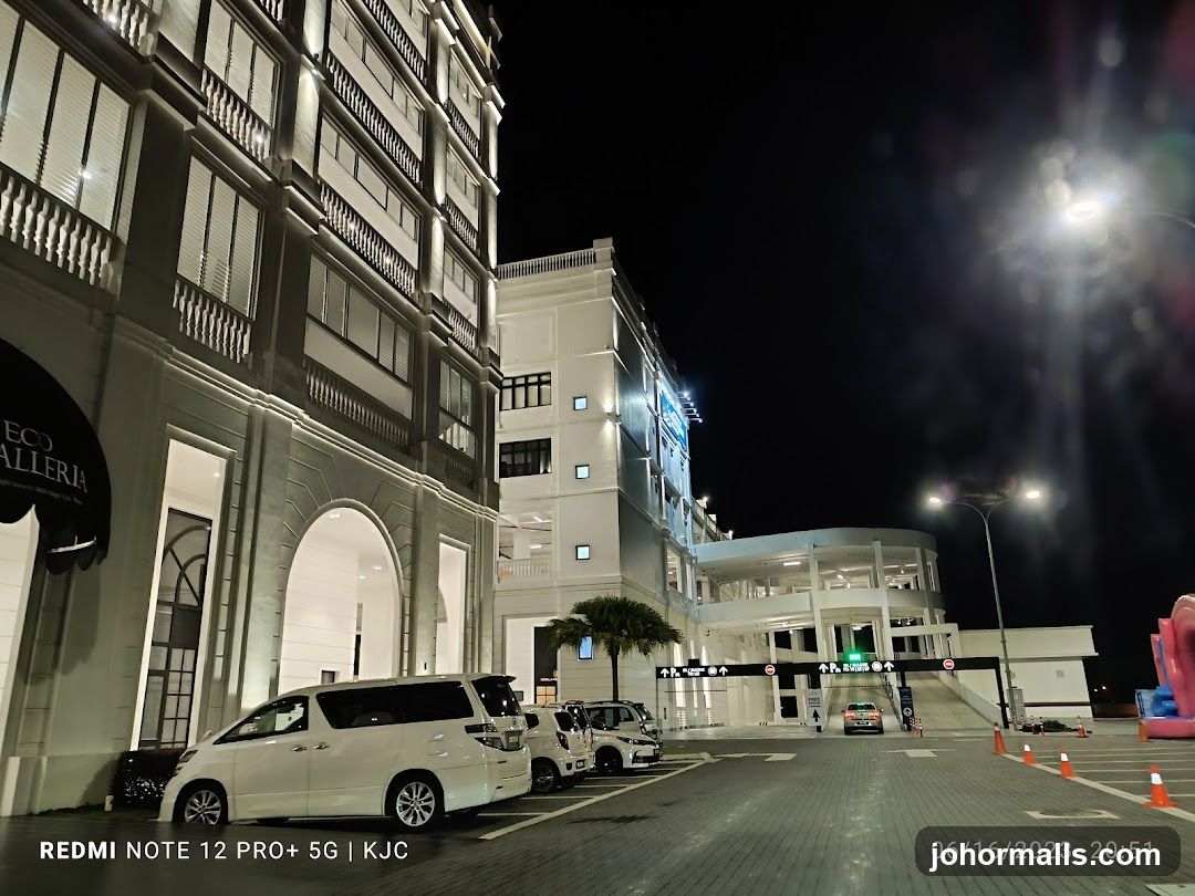 Night view of a modern building complex with cars parked