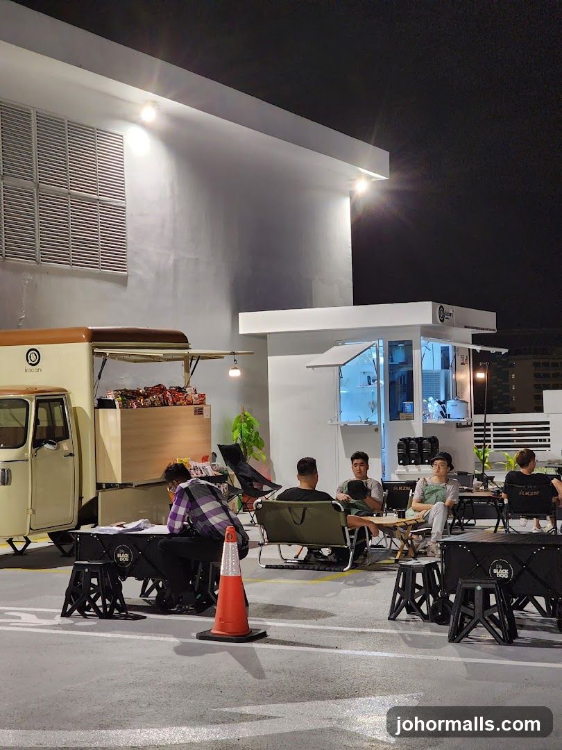 Outdoor seating area with food truck and kiosk