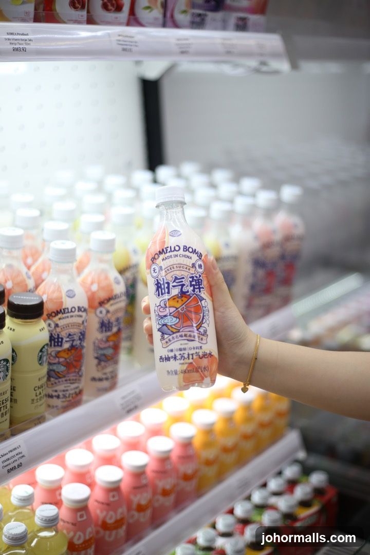 Hand holding a bottle of Pomelo Bomb drink