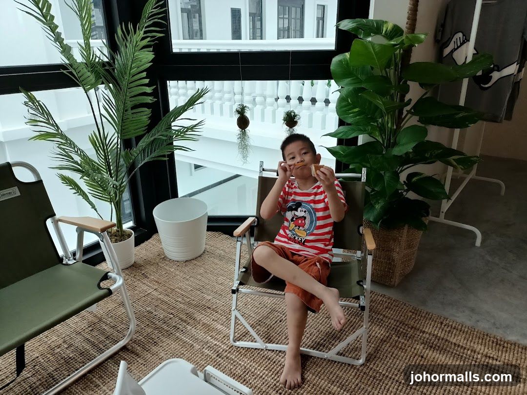 Boy eating a snack in a room with plants