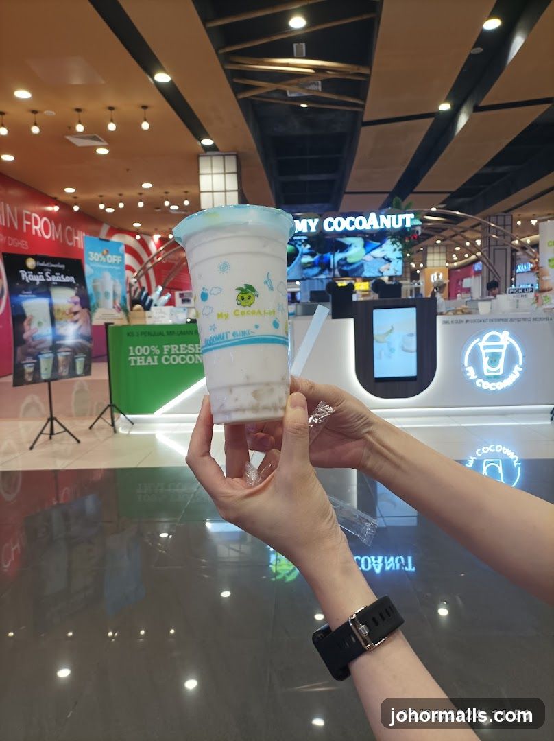 Person holding a coconut drink
