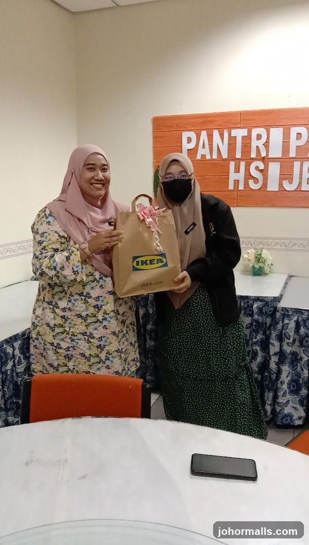 Two women holding an IKEA bag