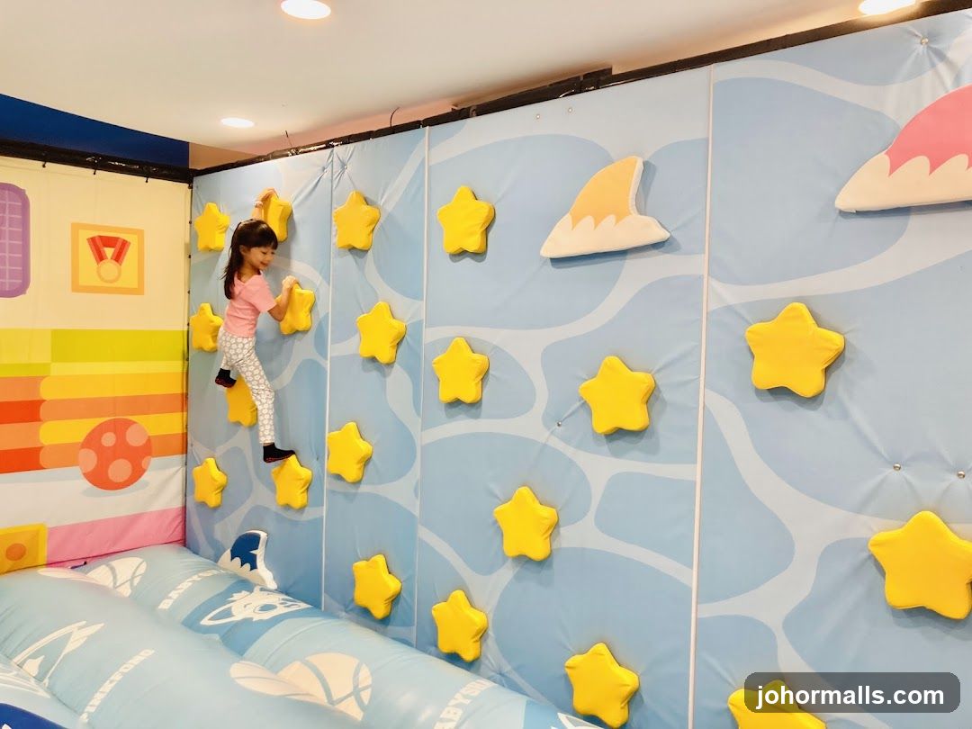 Child climbing a star-themed wall