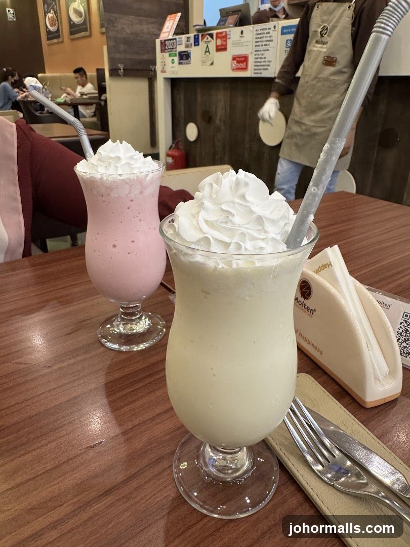 Two milkshakes with whipped cream