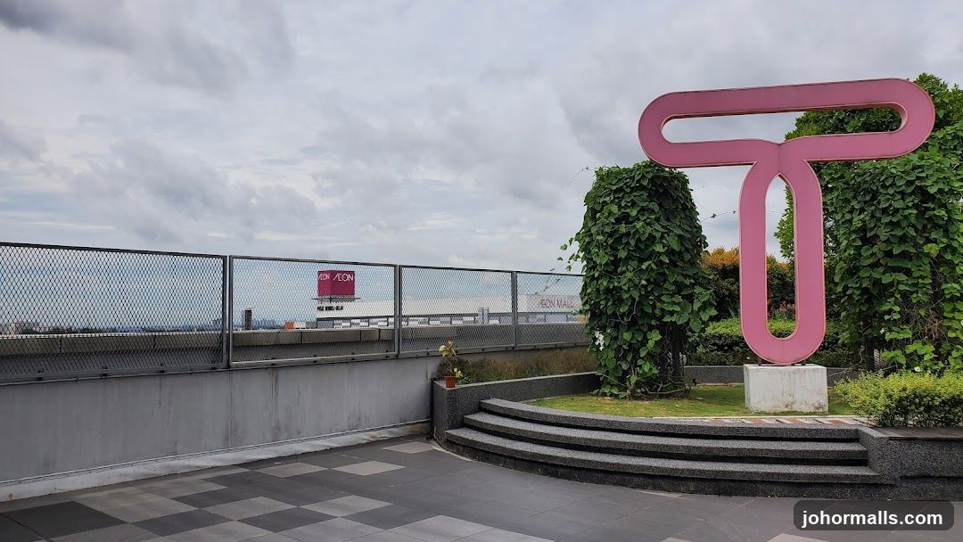 Outdoor area with sculpture and mall in background