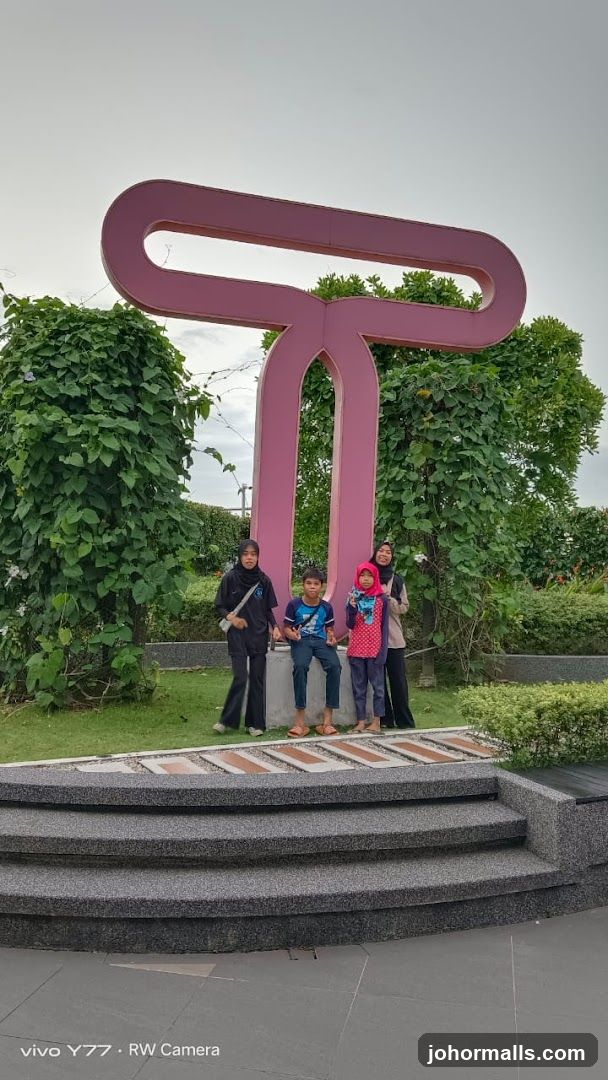 Family Poses by a Large Pink Sculpture