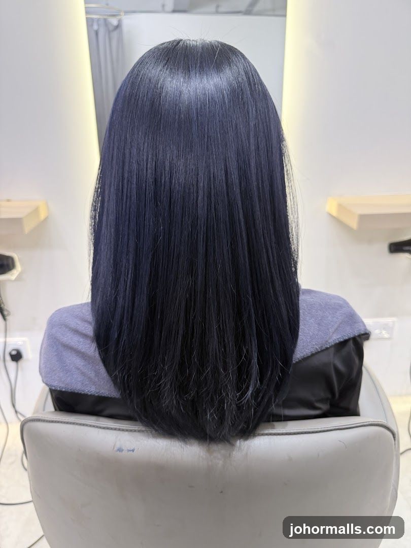 Woman with dark blue hair in a salon chair