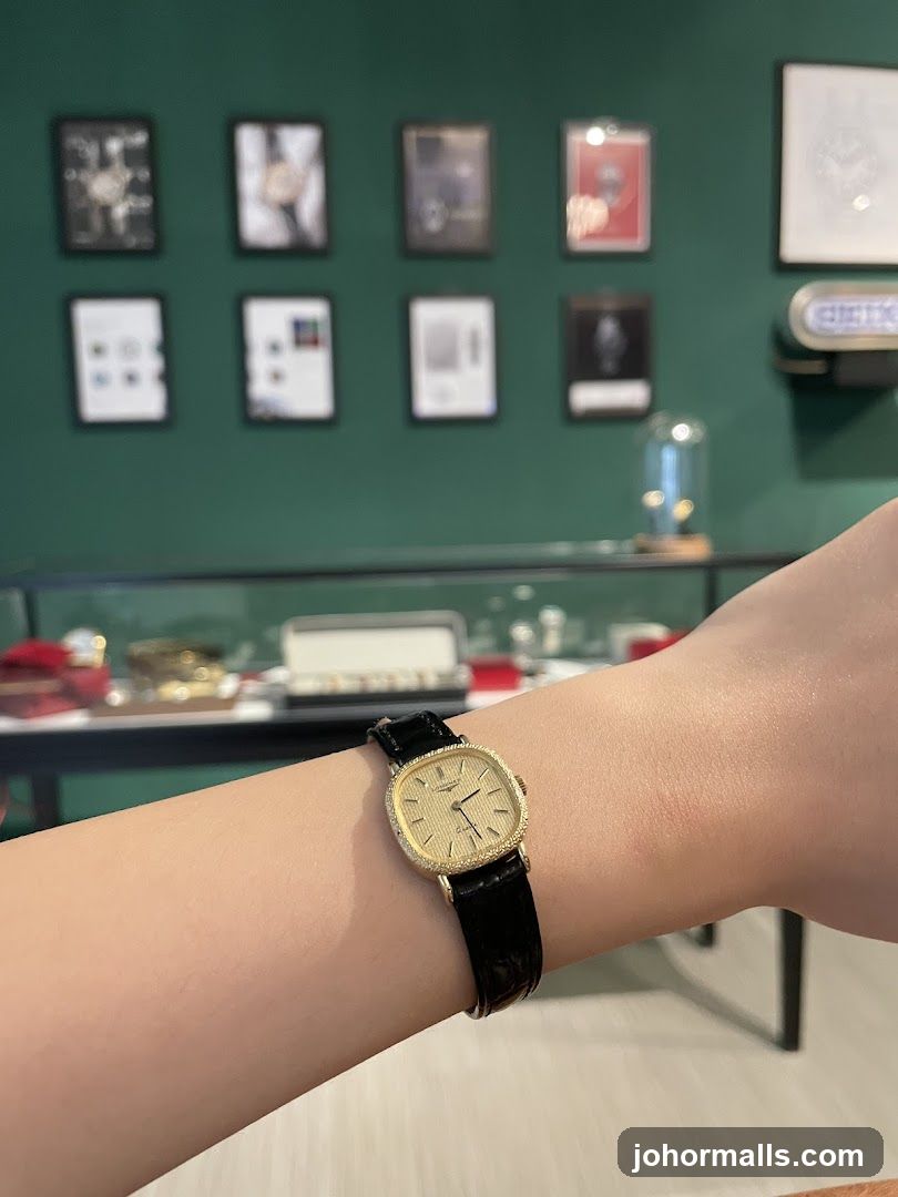 Woman wearing a gold watch with a black leather strap