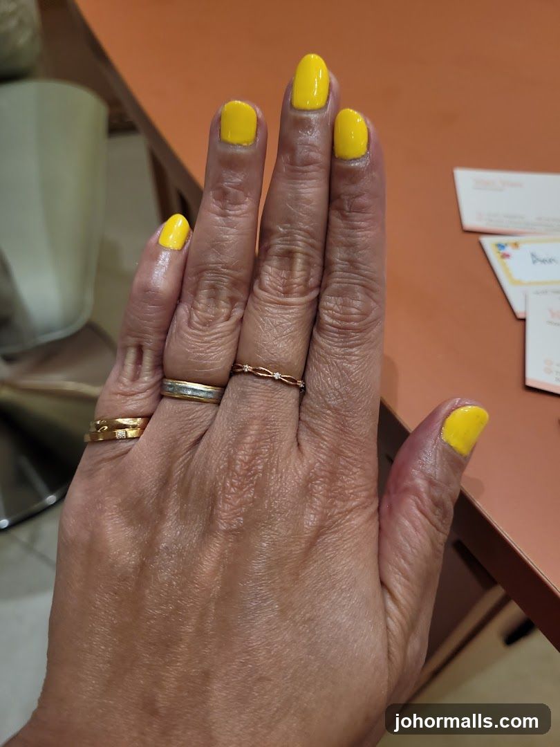 Hand with yellow nails and rings