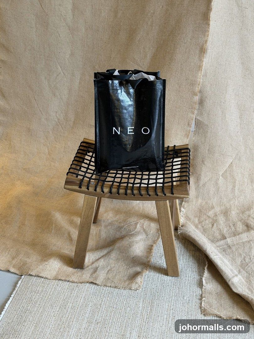 Black shopping bag with "NEO" logo on a stool