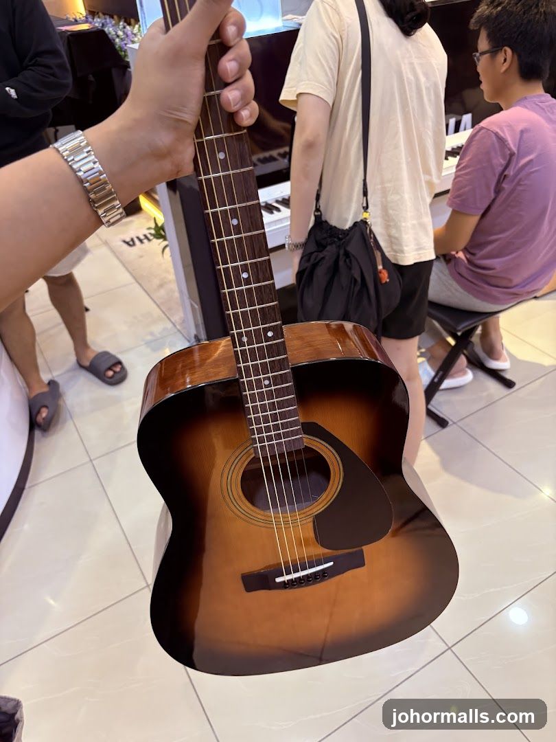 Person holding an acoustic guitar in a music store