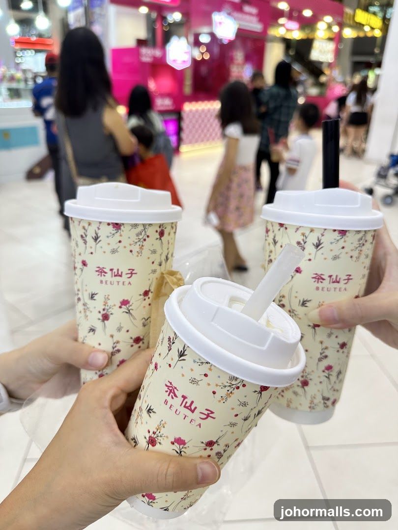Three floral patterned cups with lids and straws