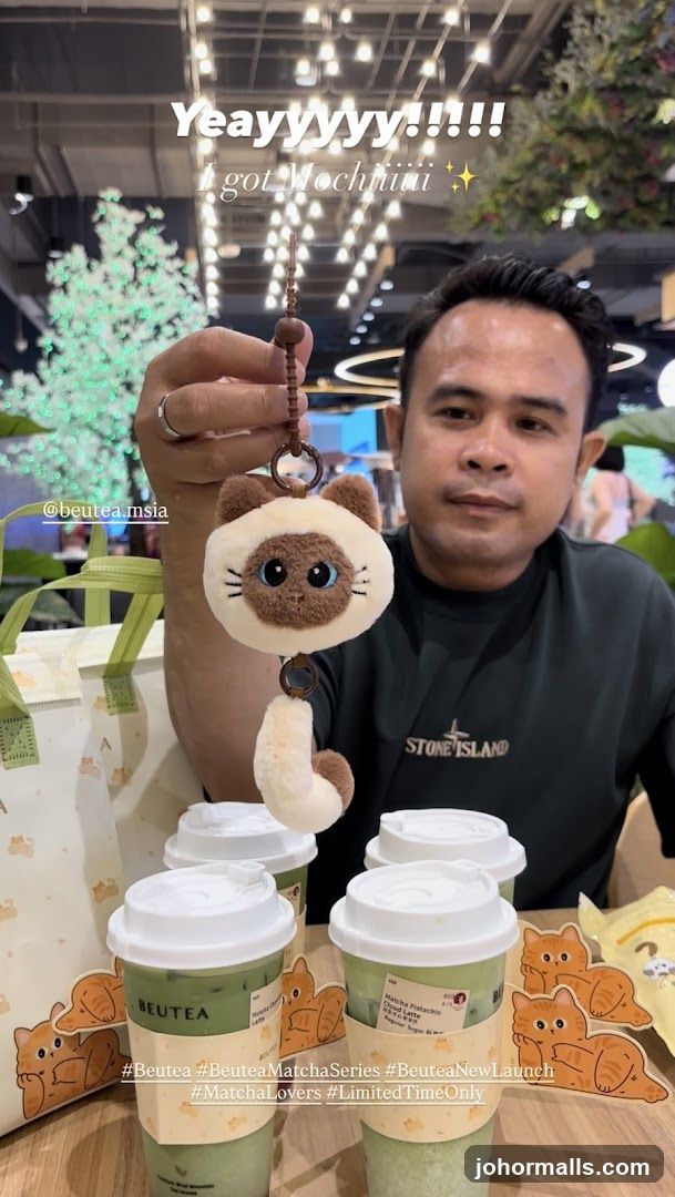 Man holding a cat keychain with matcha drinks