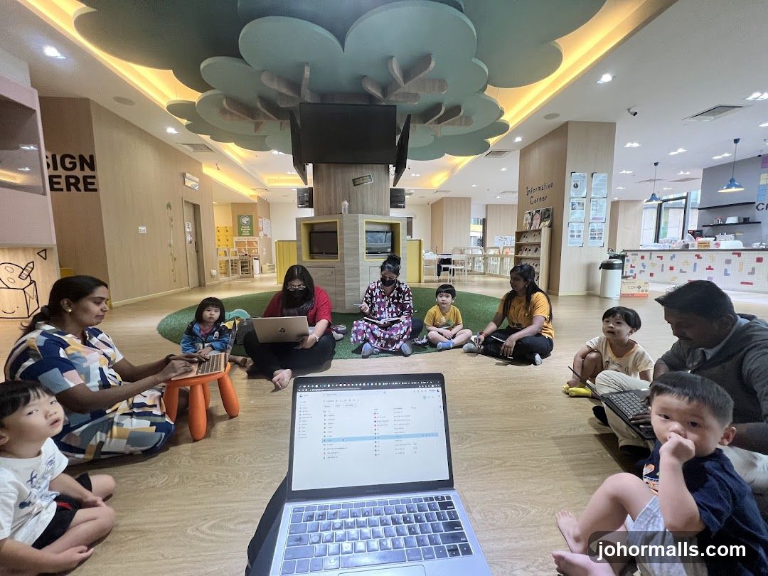 Children and adults sitting on the floor in a classroom