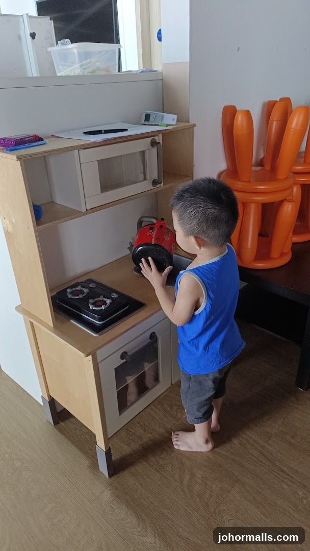 Child playing with toy kitchen