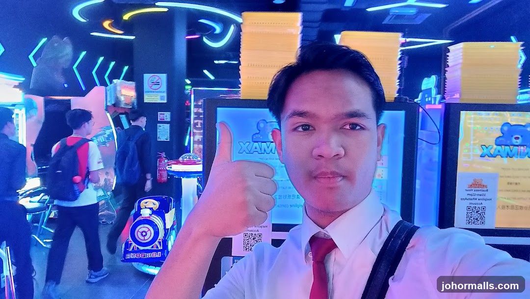 Man giving a thumbs up in an arcade