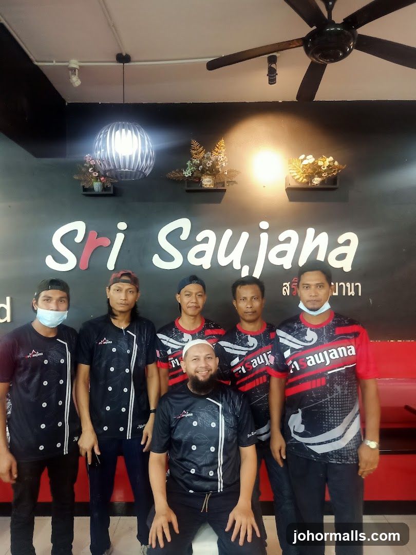 Staff Posing in Front of Restaurant Sign