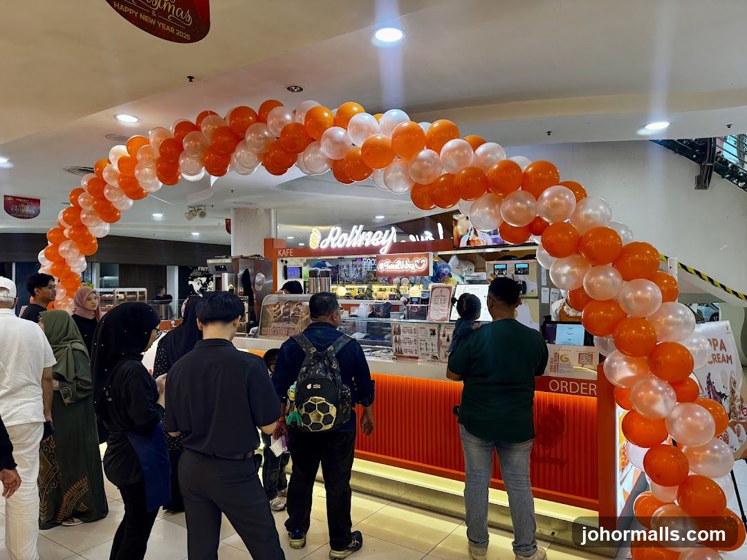 People queuing at a cafe with balloon arch