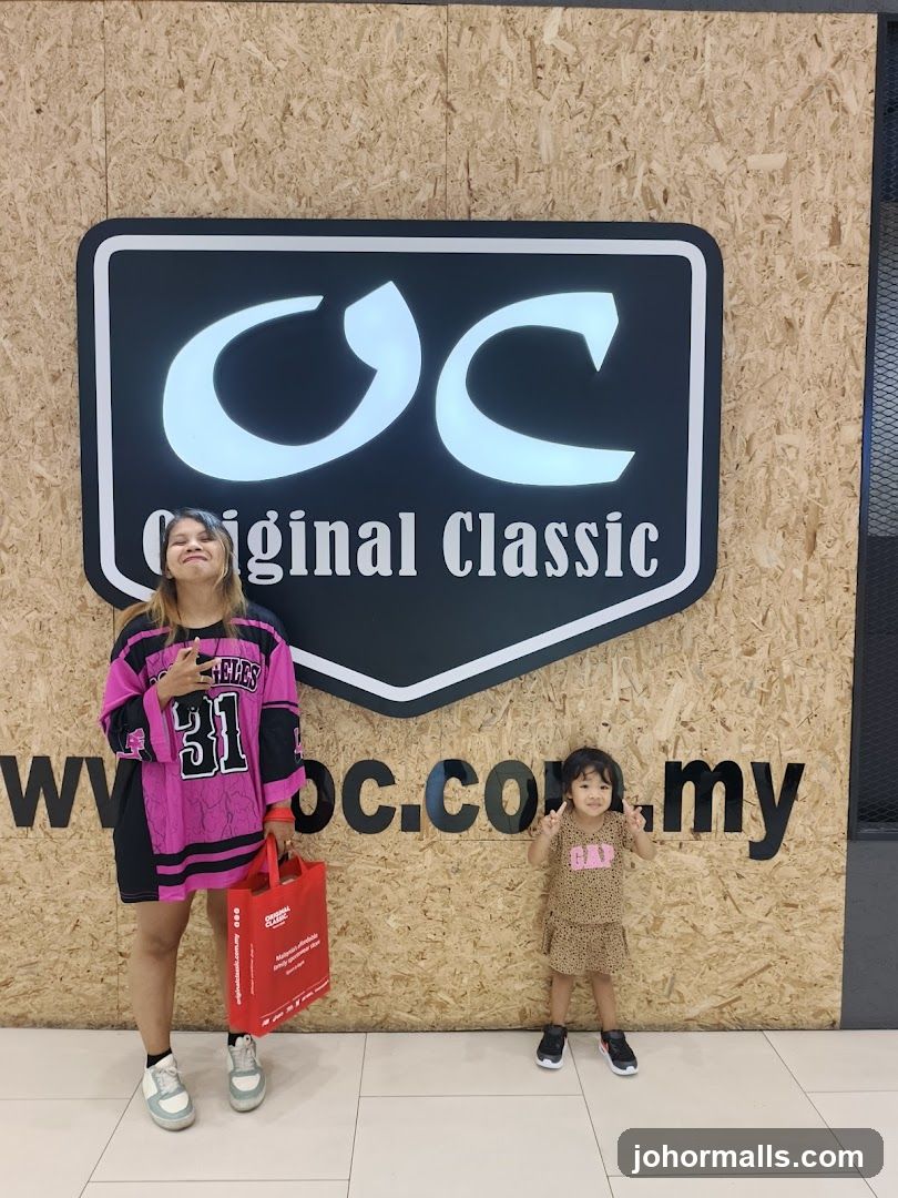 Two people posing in front of a store logo
