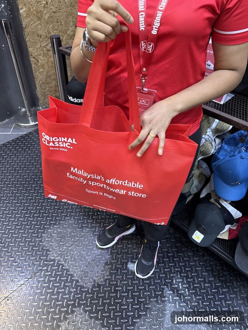 Person holding a red shopping bag