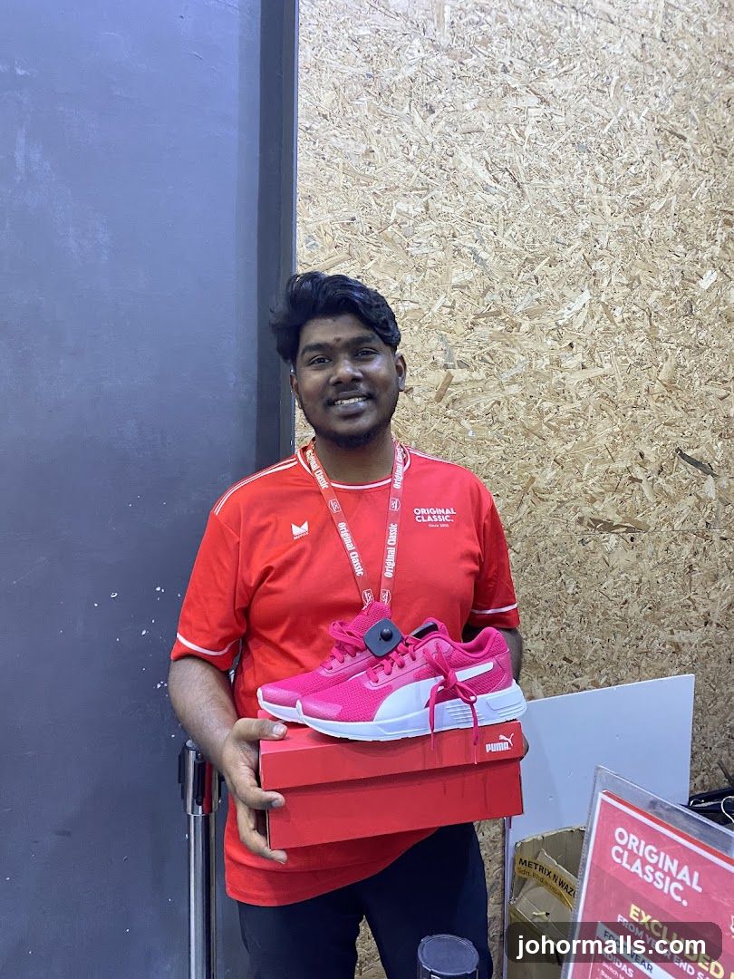Man holding pink Puma sneakers