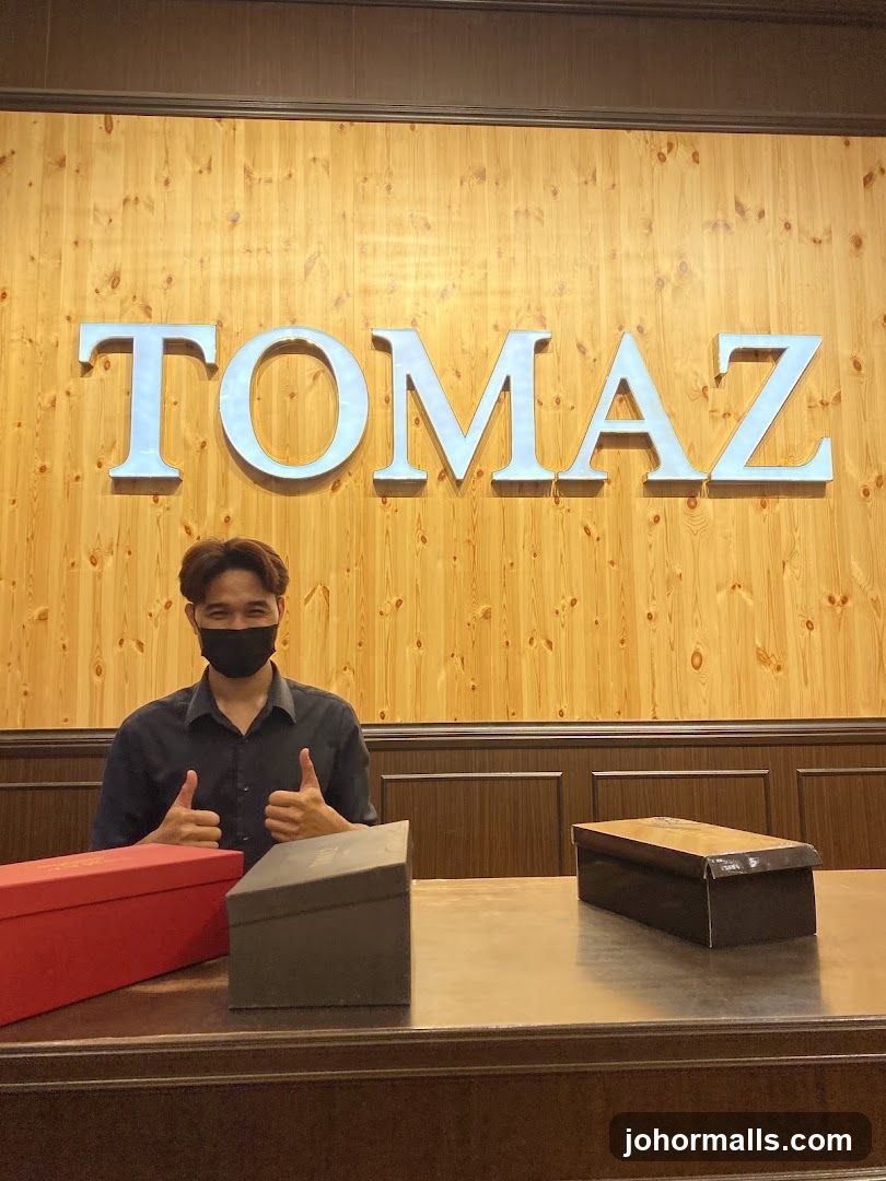 Man in front of TOMAZ sign