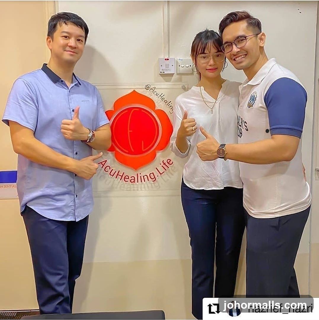 Three people posing in front of a logo