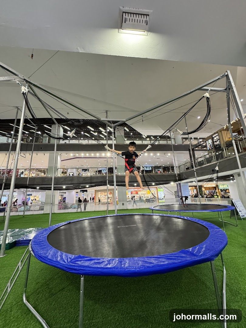 Boy jumping on a trampoline in a mall