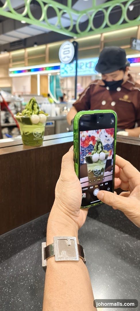 Person taking a photo of a matcha dessert