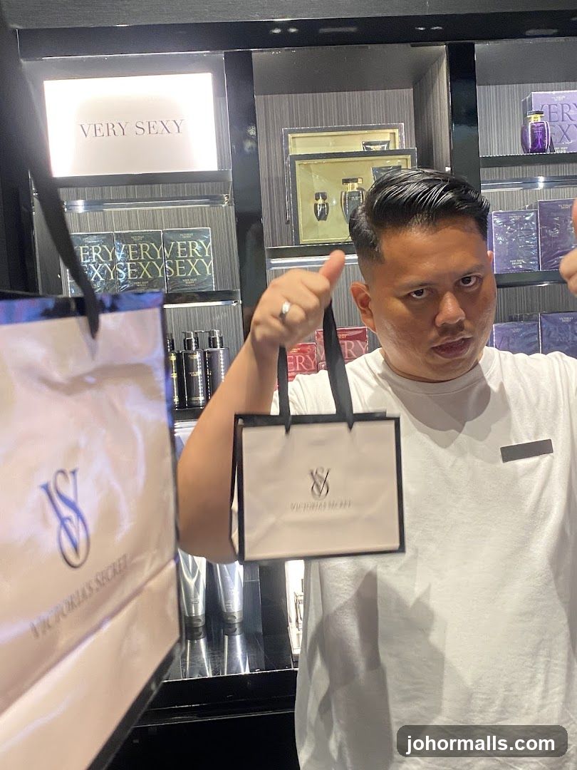 Man holding Victoria's Secret shopping bags