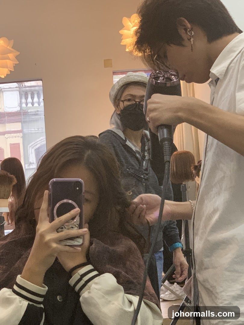 Hairdresser drying client's hair