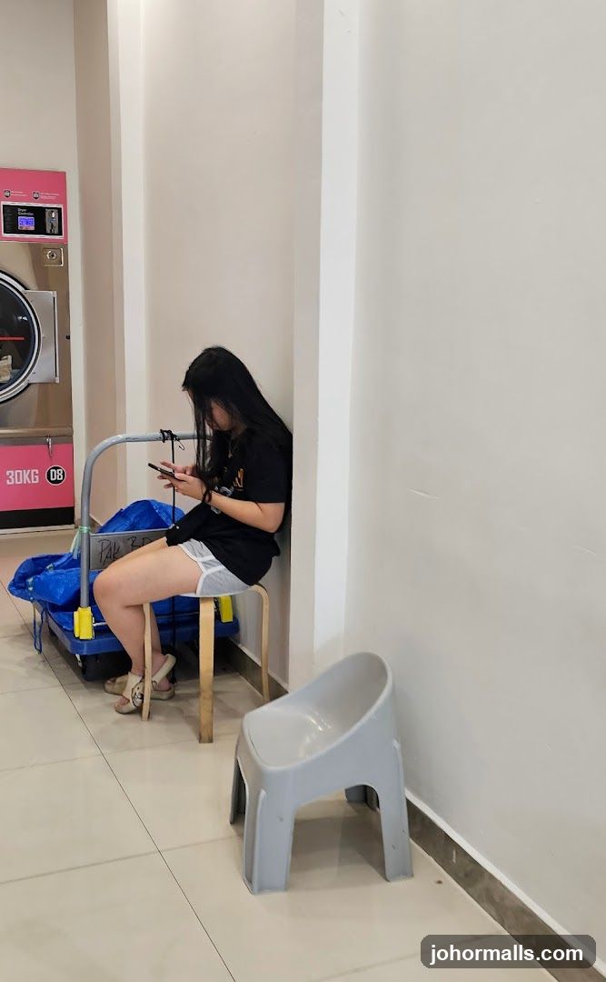 Woman using phone in laundromat
