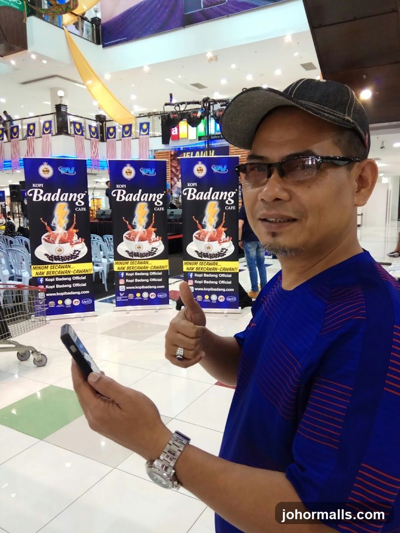 Man with Kopi Badang banners