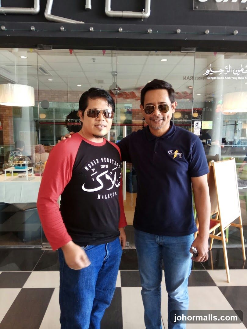 Two men posing in front of a restaurant