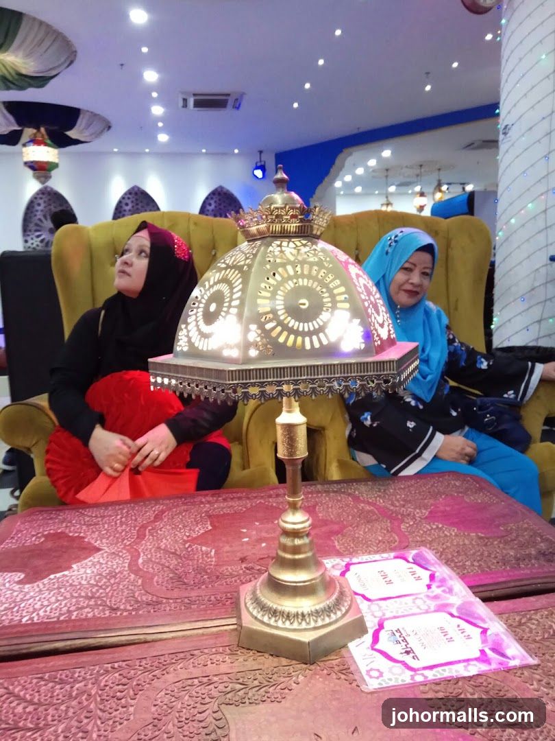 Two women sitting on chairs with a lamp in the foreground