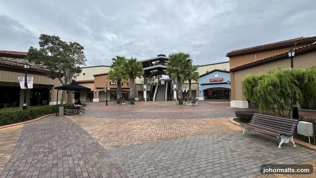 Outdoor shopping center with palm trees and escalators