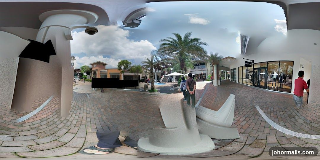 Outdoor shopping area with storefronts and palm trees