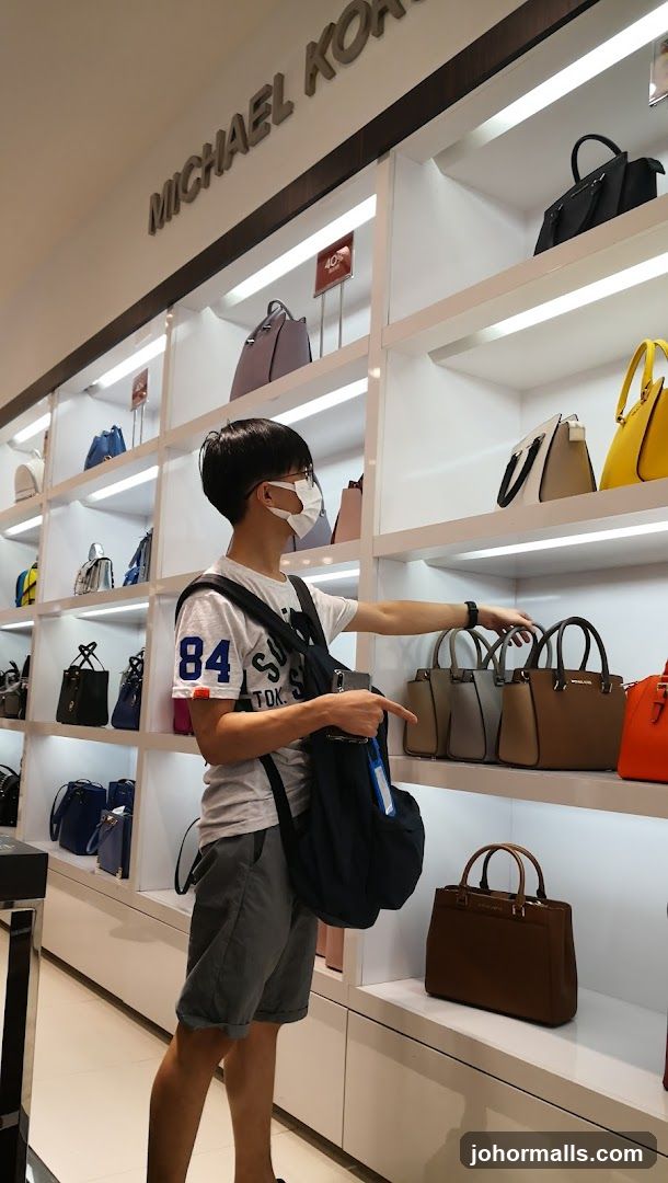 Man browsing handbags in a store