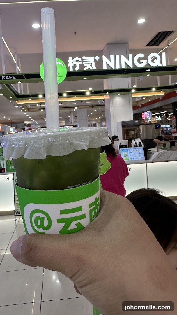Person holding a green beverage