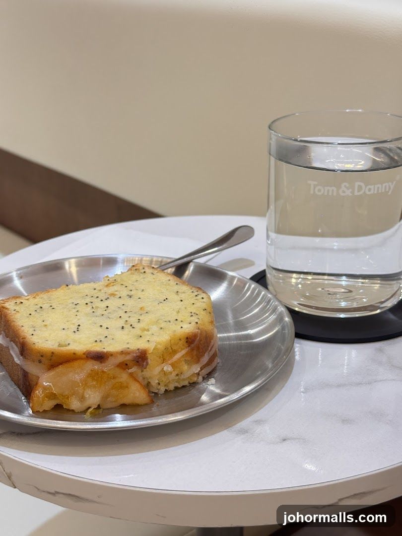 Poppy Seed Cake Slice with Iced Glaze and Water